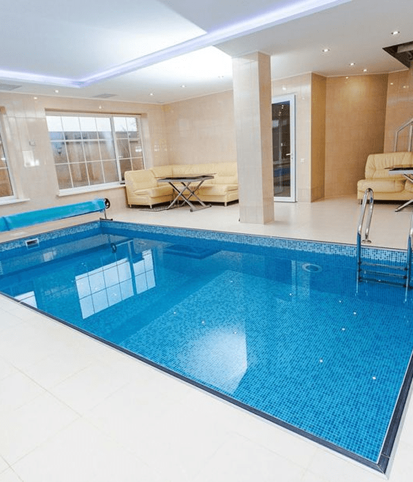 Indoor pool with seating and bright lighting.