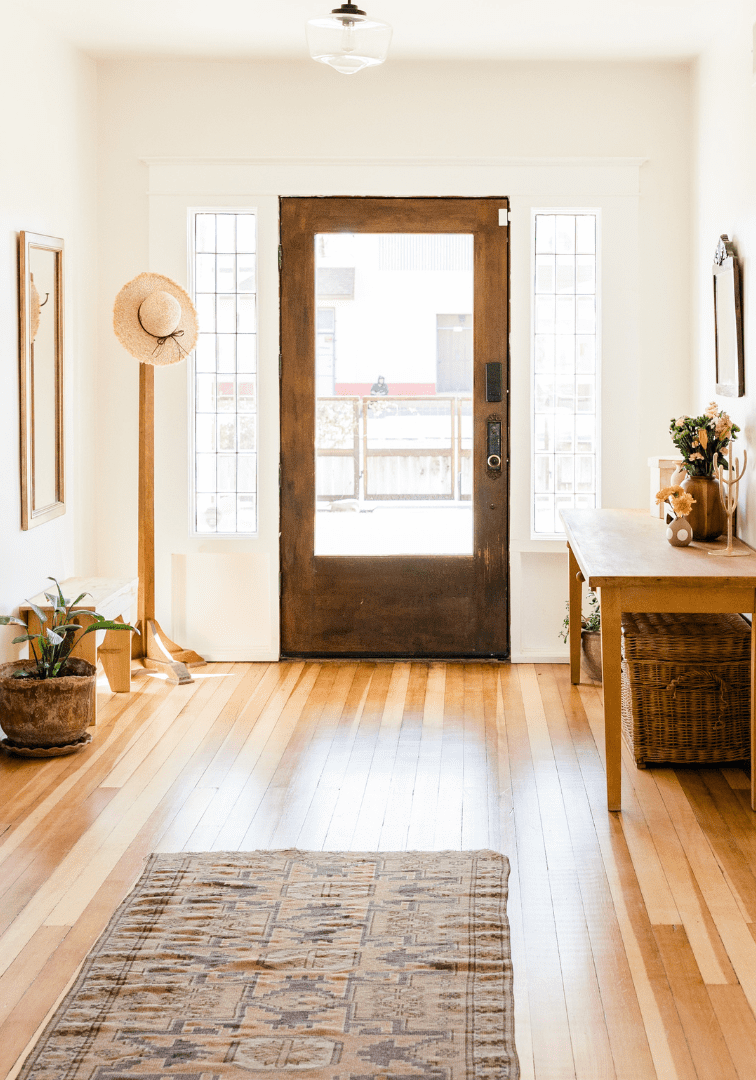 Bright hallway with wooden floor and plants.